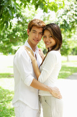 Naklejka premium Couple standing together, embracing, looking at camera