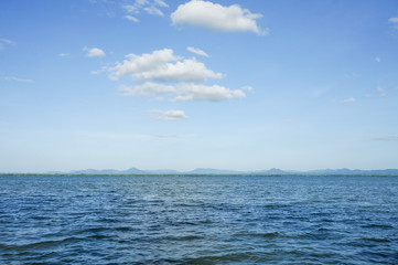 Big clouds rising up over the calm water.