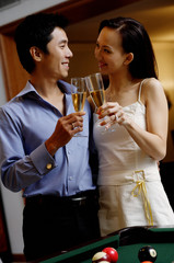 Couple standing side by side, toasting with champagne glasses