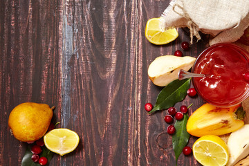 Berry and fruit jam with ingredients on a dark rustic background. Copy space, top view.
