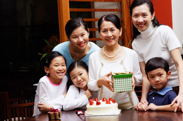Family celebrating birthday, looking at camera