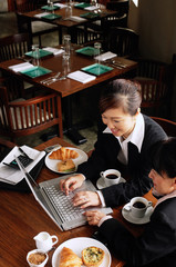 Businesswomen at cafe, using laptop