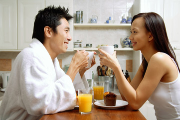 Couple in kitchen, having breakfast