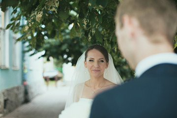 Happy bride with cute bouquet and her groom