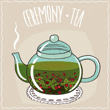 Fototapeta Transparent glass teapot with hot brewed tea currant, lie on a lacy napkin. Beige background and ornate lettering Ceremony tea. Handmade cartoon style
