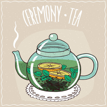 Fototapeta Transparent glass teapot with hot brewed tea with mint, lie on a lacy napkin. Beige background and ornate lettering Ceremony tea. Handmade cartoon style