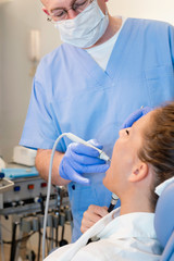 Dentist at work. Dentist removing dental calculus
