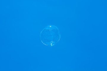 Fototapeta na wymiar Soap bubble on blue sky background