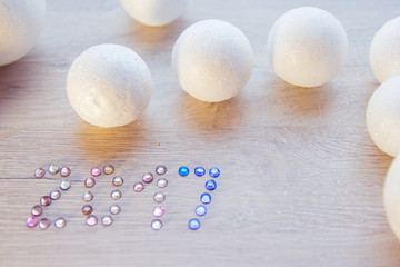 many small white balls toys symbol of the new year on a wooden , top view, there is a place for...