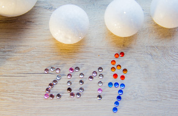 many small white balls toys symbol of the new year on a wooden , top view, there is a place for text as the background and the substrate, there are numbers of new 2017