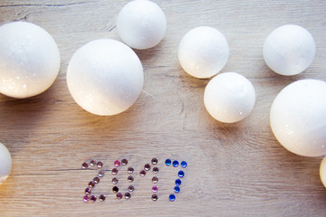 many small white balls toys symbol of the new year on a wooden , top view, there is a place for...
