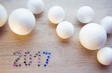 many small white balls toys symbol of the new year on a wooden , top view, there is a place for...