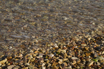 Sea water with a lot of different colors stones