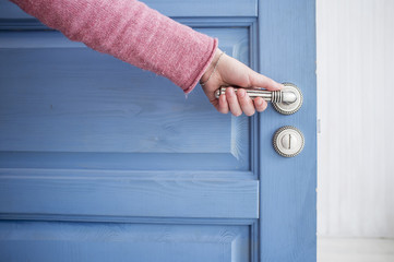 Fototapeta premium man holding a metal pen in an open wooden door blue