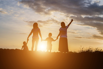Fototapeta premium Happy family dancing on the road in the sunset time. Evening par