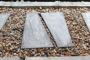 Wooden plank and stone walkway in garden.