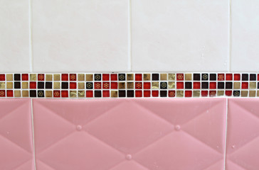 Pink light, white and mosaic wall tiles.