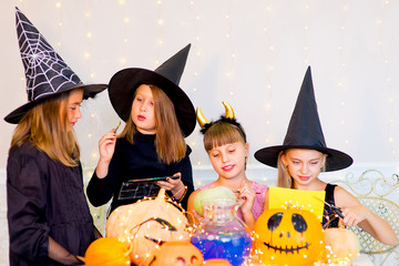 Happy group of teenagers in costumes preparing for Halloween