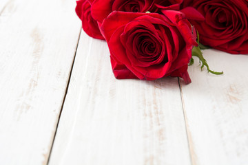Red roses on white wooden background.copyspace


