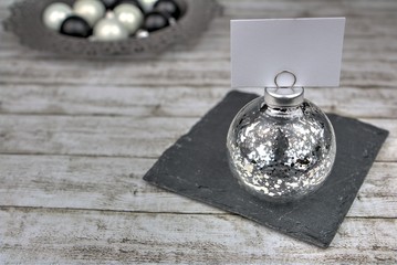 festliche Dekoration und Kugel mit Blatt zur Beschriftung auf Schieferplatte 