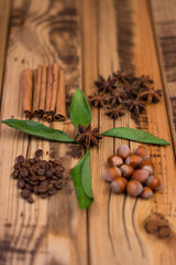 Cinnamon sticks, cocoa beans, star anise, hazelnuts on wooden background