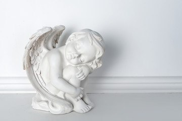 Statue of Sleeping Cupid on white background with copy space for text
