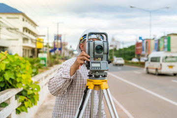 A surveyor at work with an infrared reflector used for distance measurement on roadside
A land...