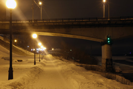 Night lights on the bridge and snow on the river