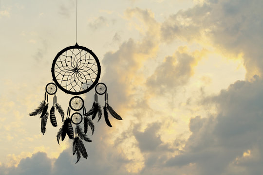 Indian dreamcatcher silhouette at sunset