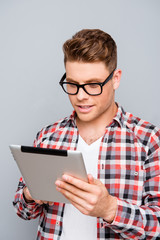 Handsome man in glasses using digital tablet to read news