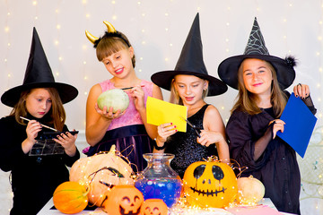 Happy group of teenagers in costumes preparing for Halloween