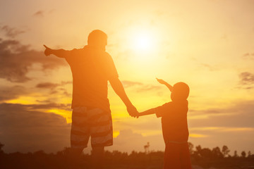 Fototapeta premium Happy dad throws the baby at sunset