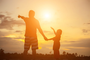 Fototapeta premium Happy dad throws the baby at sunset