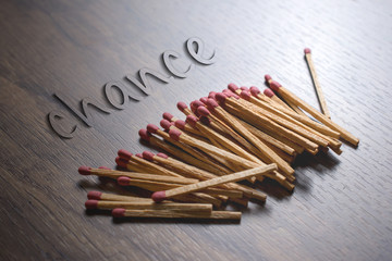 matches on wood table baclground with chance text.