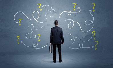 Unsure businessman with question marks