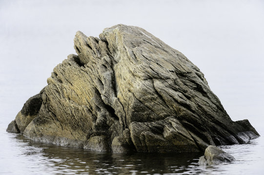 Big rock in water near shore