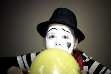 Girl with a balloon in the form of mime actor