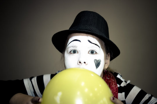 Girl with a balloon in the form of mime actor