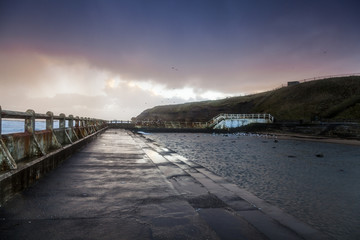 Fototapeta premium Old Tynemouth Outdoor Pool on a cold and stormy morning.