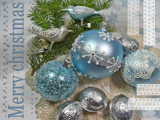 Hellblaue, reich verzierte Weihnachtskugeln, silberne Walnüsse und Glasvögel auf Tannengrün und...