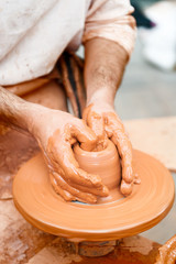 close-up of hands working with clay on turntable artisan
