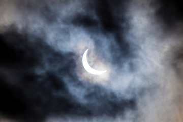 Naklejka na ściany i meble Partial solar eclipse through clouds