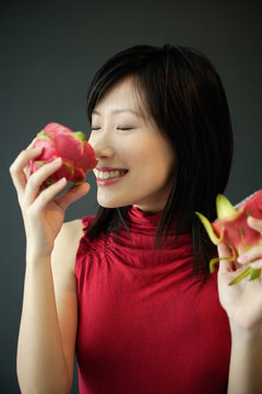 Woman smelling dragon fruit