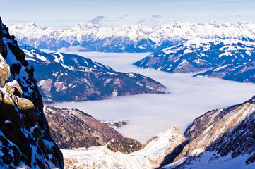 View of the Zel am See foggy valley from the top of Kaprun glacier in austrian alps, Austria - obrazy, fototapety, plakaty