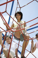 Young women climbing ropes at playground