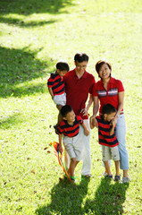 Family with three boys, standing on field, looking at camera