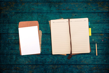 Notebook with pen on a dark wood table