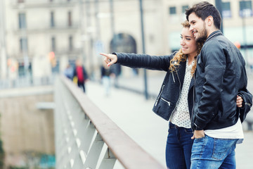 Smiling young couple pointing something on an autumns day.