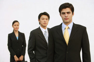 Business people standing, looking at camera, in a row