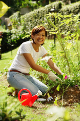 Fototapeta premium Woman gardening, smiling at camera